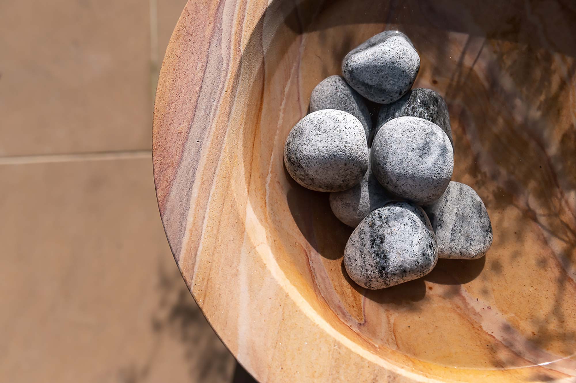 pebbles in sandstone bowl